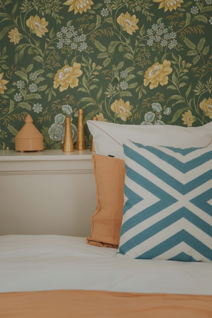 Bedroom with sky blue zigzag cushion and Garden Muse wallpaper