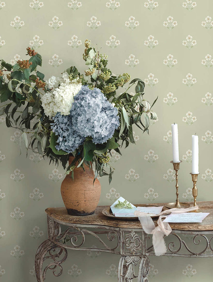 Sage green Isadora floral sprig wallpaper on a bedroom wall