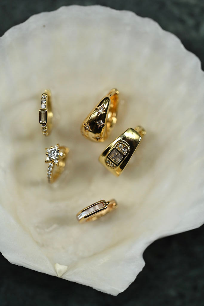 Gold rings with gemstones on a white shell