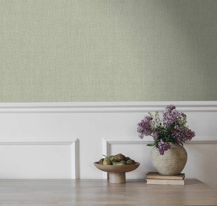 Sage green Ormsby linen texture wallpaper on a living room wall