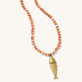Pez necklace with papaya-colored carnelian beads and an articulated gold fish charm